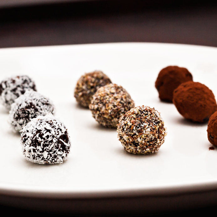 homemade chocolate treats, rolled in shredded coconut, ground flax seeds and cocoa powder